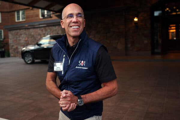 Mr. Katzenberg, wearing a dark T-shirt under a navy zip-up vest, clasping his hands and smiling. 